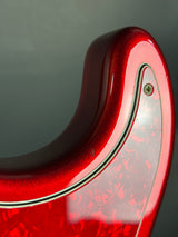 Close-up of a red guitar with a glossy finish on a gray background