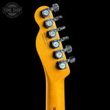 Close-up of a guitar headstock with tuning pegs on a black background, featuring the Tone Shop logo.