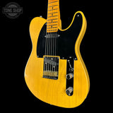 Yellow electric guitar with a black pickguard on a black background, featuring the Tone Shop logo.