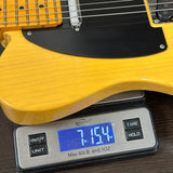 Yellow electric guitar on a digital scale displaying weight