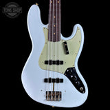 A light blue electric bass guitar with a cream-colored pickguard, black control plate, and dark brown fretboard, shown against a solid black background. A Tone Shop watermark is visible in the top left corner.