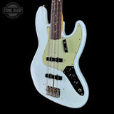 A light blue Fender Stratocaster-style bass guitar with a pale yellow-green pickguard, black control knobs, and a dark fretboard, shown against a black background with a Tone Shop watermark in the top left.