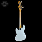 A single-cutaway electric bass guitar shown from the back, featuring a pale icy blue body, a natural wood neck, and a headstock with four white tuning pegs. The image is set against a solid black background with a Tone Shop watermark in the upper left corner.