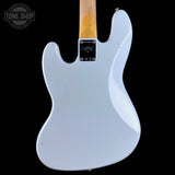 The back of a Fender Stratocaster electric guitar in a light blue finish, featuring a natural maple neck and a black hardware plate, shown against a solid black background.