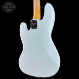 The back of a Fender Stratocaster electric guitar in a light blue finish, featuring a natural wood neck and a black Fender logo plate, shown against a solid black background.