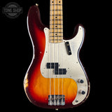 A classic Fender Strat-style bass guitar with a sunburst finish, featuring a dark red outer edge fading to a warm amber and yellow center, a white pickguard, and a maple fretboard, shown against a solid black background.