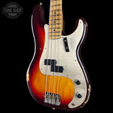 A classic Fender Strat-style bass guitar with a sunburst finish transitioning from dark red to orange, featuring a white pickguard and black hardware, shown against a black background with a Tone Shop watermark.