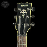 Yamaha guitar headstock with brand logo on a black background
