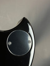 Close-up of a black object with circular metallic components on a gray background