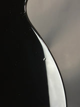Close-up of a glossy black surface with a reflective top