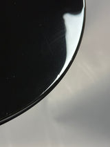 Close-up of a black disc with a reflective surface on a gray background