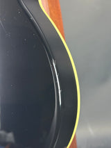 Close-up of a black object with yellow rim on a gray background