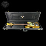 A gold-finish electric bass guitar resting inside an open black hard case on a black background, with a Tone Shop watermark in the top left corner.