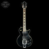 Electric guitar with a clear coat on a black background, featuring the Gibson logo.