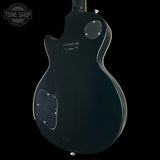 Back view of a black electric guitar with 'Tone Shop' logo.