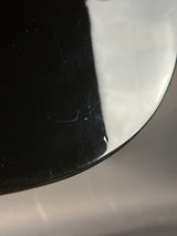 Close-up of a reflective metallic surface with a blurred background