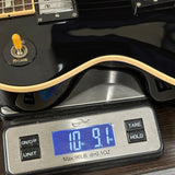 Guitar on a digital scale displaying weight