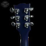 Close-up of a blue electric guitar's headstock with tuning pegs on a black background.