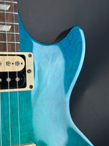 Close-up of a blue electric guitar with a dark background