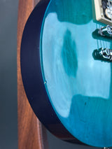 Close-up of a blue electric guitar's body with a blurred background