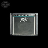 A Peavey 112 guitar amplifier cabinet shown from the front against a solid black background. The cabinet features a textured gray front, a black speaker grille with the white Peavey logo, and a control panel with knobs at the top.