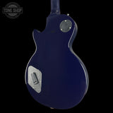 Blue electric guitar body with 'Tone Shop' logo in the corner