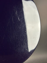 Close-up of a black surface with white paint and visible scratches.
