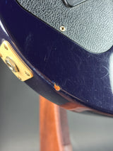 Close-up of a guitar with visible wear and a gold pickguard.