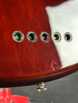 Close-up of a guitar's soundhole with control knobs.