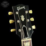 Gibson guitar headstock with tuning pegs on a black background