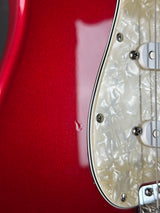 Close-up of a red electric guitar with pearl inlay on the fretboard.