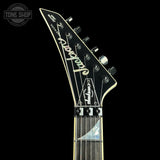 Close-up of a guitar headstock with 'Jackson' branding on a black background
