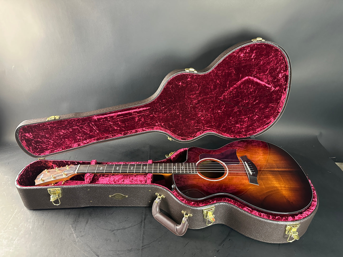 Acoustic guitar in an open case on a gray surface