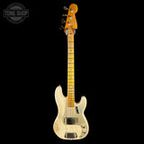 A classic Fender bass guitar with a distressed cream finish, maple neck, and gold-toned headstock, shown against a solid black background with a Tone Shop watermark in the top left corner.