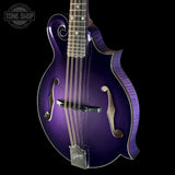 A purple Gibson mandolin with a glossy metallic finish, featuring gold-toned hardware and a dark fretboard, shown against a solid black background with a Tone Shop watermark in the top left corner.