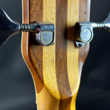 Close-up of a wooden archery bow with metal nocks on a dark background