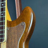 Close-up of a guitar's wooden neck and fretboard against a dark background