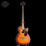 Acoustic guitar with a sunburst finish on a black background, featuring the Tone Shop logo.