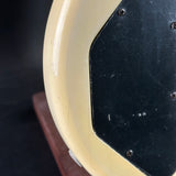 Close-up of a wooden object with a metallic plate on a dark background