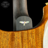 Close-up of the headstock and upper body of a wooden stringed instrument, showing a dark wood neck with an iridescent butterfly inlay and a warm honey-toned wood body against a black background. A Tone Shop watermark appears in the top-left corner.