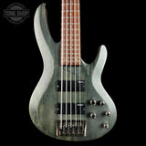 Electric bass guitar with a metallic finish on a black background, featuring the Tone Shop logo.