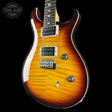 Electric guitar with a sunburst finish on a black background, featuring the Tone Shop logo.