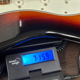 Used Fender Player Strat 3-Color Sunburst on scale displaying weight.