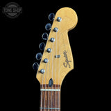 Guitar headstock with 'Squier' branding on a black background