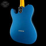 The back of a blue Fender Telecaster electric guitar with a yellow neck, shown against a solid black background. A Tone Shop watermark is visible in the top left corner.