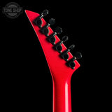 Close-up of the headstock of a red electric guitar against a black background, showing six black tuning pegs and a Tone Shop watermark in the top left corner.