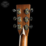 Close-up of a guitar headstock with tuning pegs on a black background, featuring the Tone Shop logo.