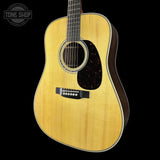 Acoustic guitar with a visible brand logo on a black background