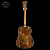Wooden acoustic guitar on a black background with 'Tone Shop' logo.