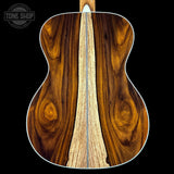 Close-up of a wooden acoustic guitar's back and sides with 'Tone Shop' branding.